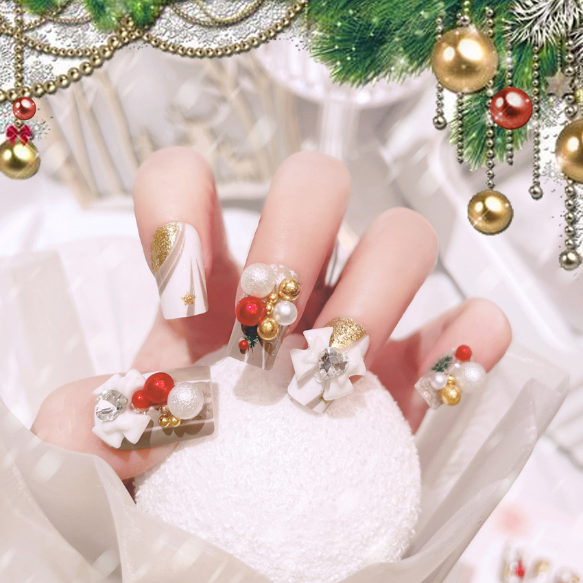 Ongles à coller avec des boules en forme de nœuds de Noël